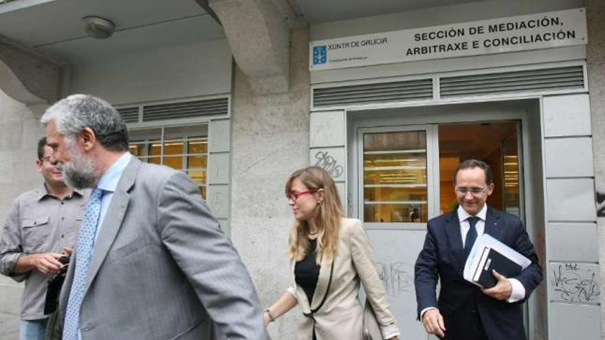 Los procuradores de los exdirectivos y del banco, a la salida del acto de conciliación, en Vigo. / jesús de arcos