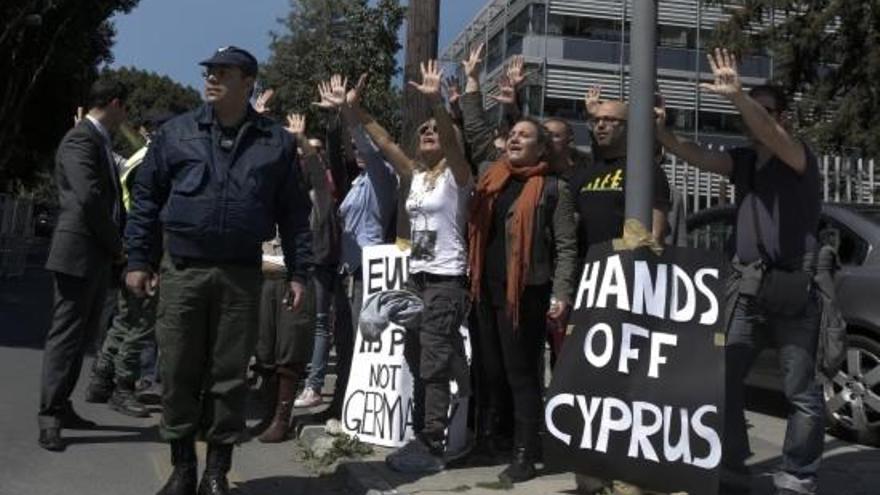 Manifestants xipriotes protesten amb pancartes de &#039;Xipre, mans enlaire!&#039;