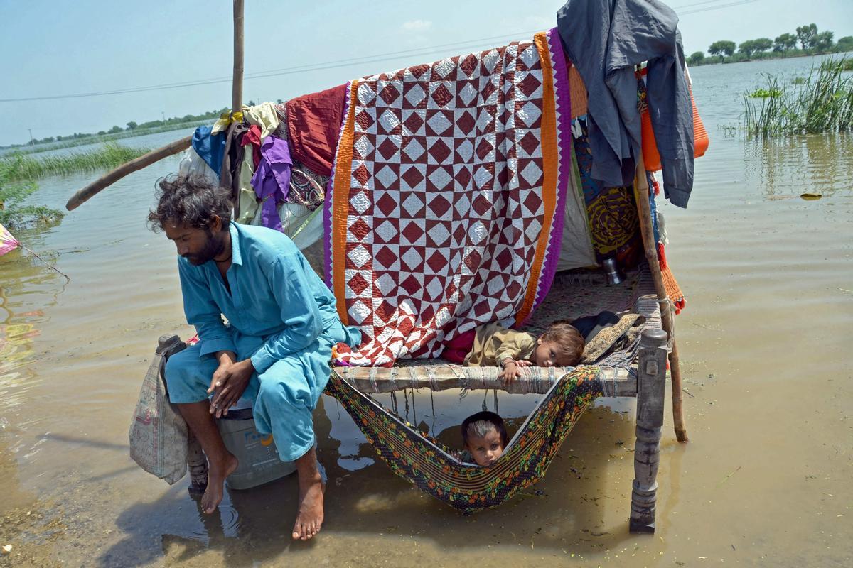 Un hombre y su hijo, afectados por las inundaciones, en el distrito de Jaffarabad, en Pakistán, el 31 de agosto del 2022.
