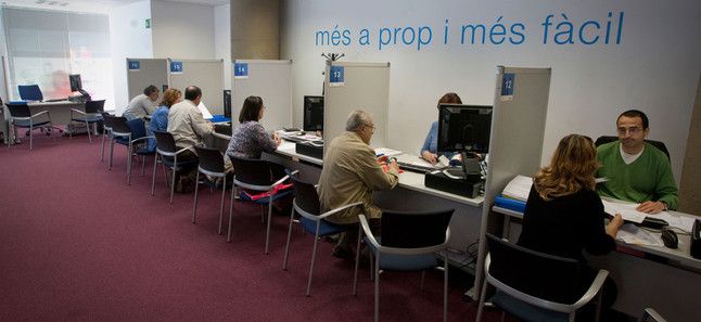 Varias personas tramitan su declaración del IRPF en una delegación de Hacienda en Barcelona, durante una anterior campaña de la renta. DANNY CAMINAL