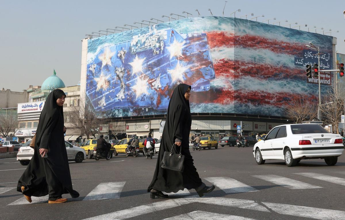 Dos mujeres caminan frente a un mural antiestadounidense, este sábado en Teherán.