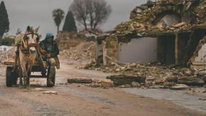 Un hombre en carro pasa junto a unos edificios derrumbados por el terremoto de febrero de 2023 en el centro de Antioquía.