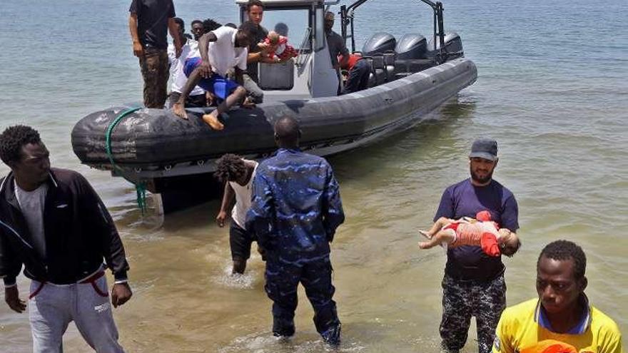 La Guarda Costera libia evacua a los supervivientes del naufragio y uno de los bebés recuperados. // AFP