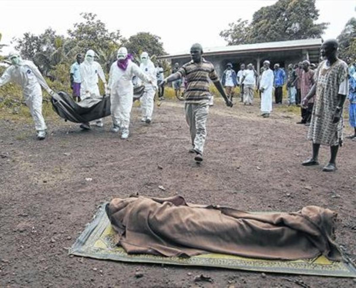 Uns infermers traslladen una víctima de l’Ebola, a Monròvia (Libèria).