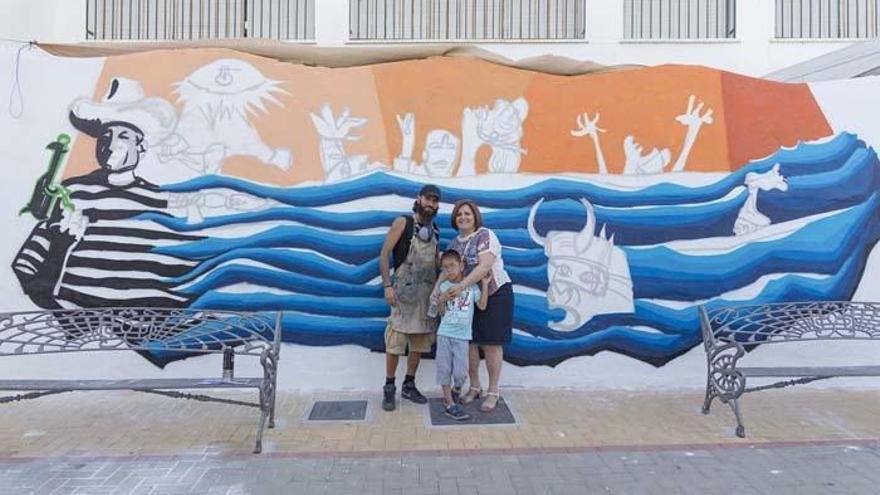 El artista Juanma Rivero junto una de las vecinas de Tolox, María Fernández y su hijo Pablo, a quien le fascina esta vanguardista obra basada en la obra cumbre de Picasso.