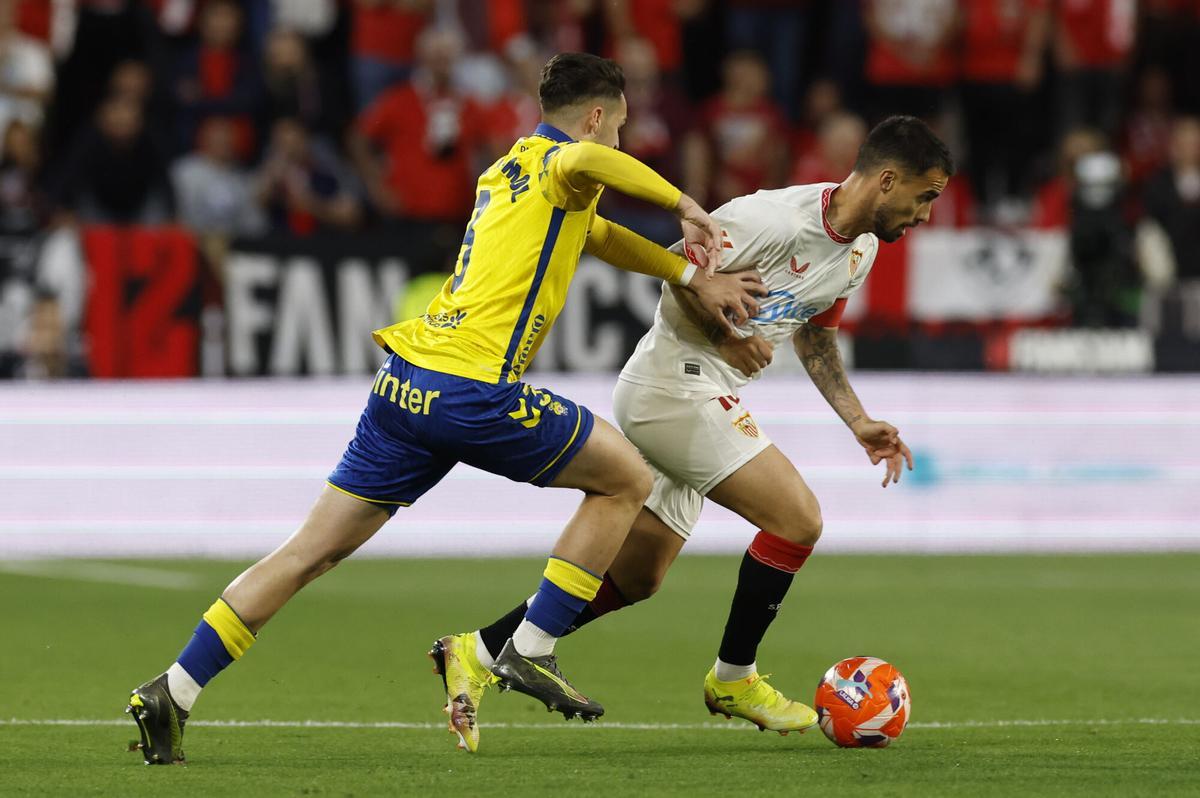 SEVILLA, 13/05/2025.- El centrocampista del Sevilla FC Suso Fern芍ndez (d) se escapa de Mika Marmol, de la UD Las Palmas, durante el partido de la jornada 36 de LaLiga que Sevilla FC y UD Las Palmas disputan este martes en el estadio Ram車n S芍nchez-Pizju芍n. EFE/Julio Mu?oz
