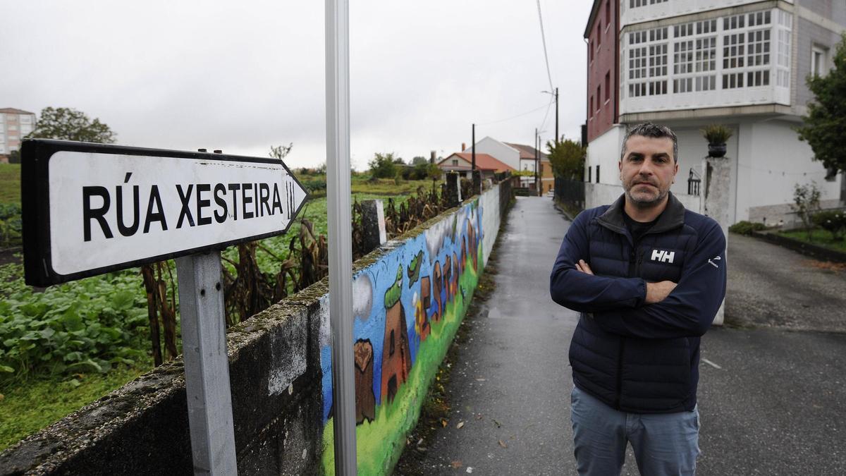 Óscar Expósito, vecino de la Rúa Xesteira, posa junto a la señal que marca el inicio de su calle.
