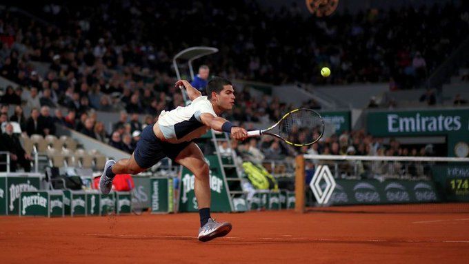 Alcaraz se estira para devolver la bola a Zverev.