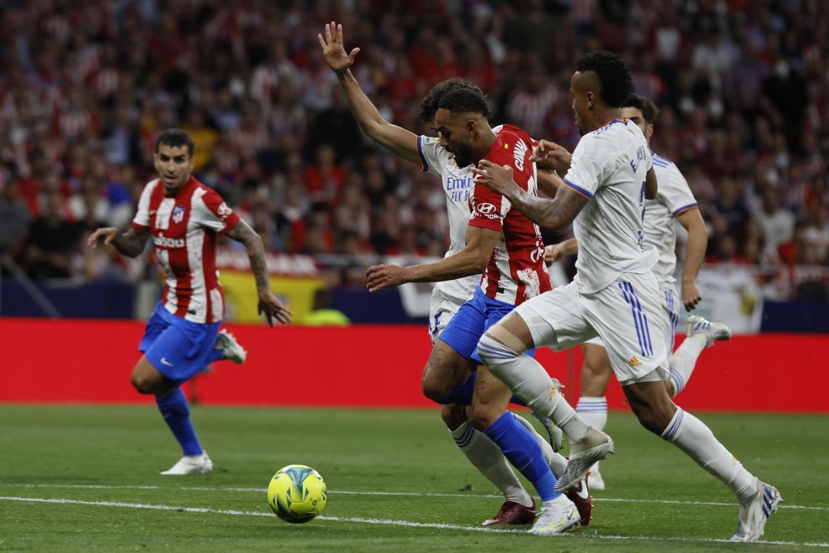 MADRID, 08/05/2022.- El delantero brasileño del Atlético de Madrid, Matheus Cunha (c), intenta llevarse el balón ante los defensas del Real Madrid, Jesús Vallejo (i) y el brasileño Militao, en la jugada que ha significado el penalti a favor del equipo rojiblanco durante el encuentro correspondiente a la jornada 35 que disputan hoy Domingo en el estadio Wanda Metropolitano, en Madrid. EFE / Ballesteros.