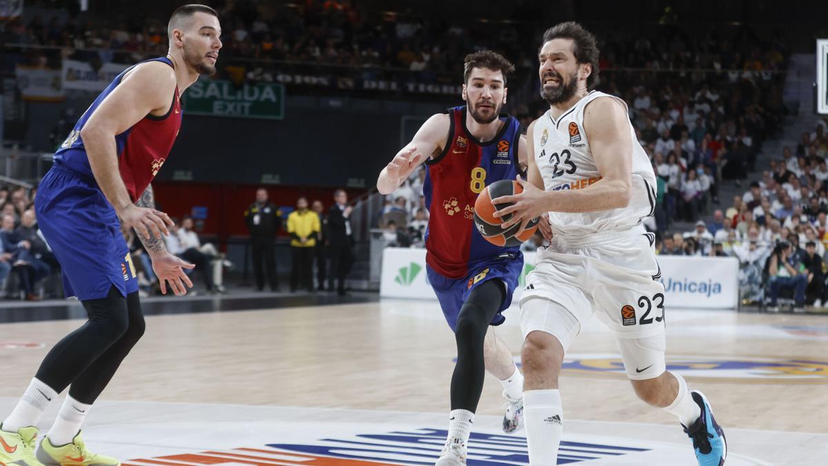 El base del Real Madrid Sergio Llull entra a canasta junto a Darío Brizuela, del Barça, durante el partido de la jornada 27 de la EuroLiga.