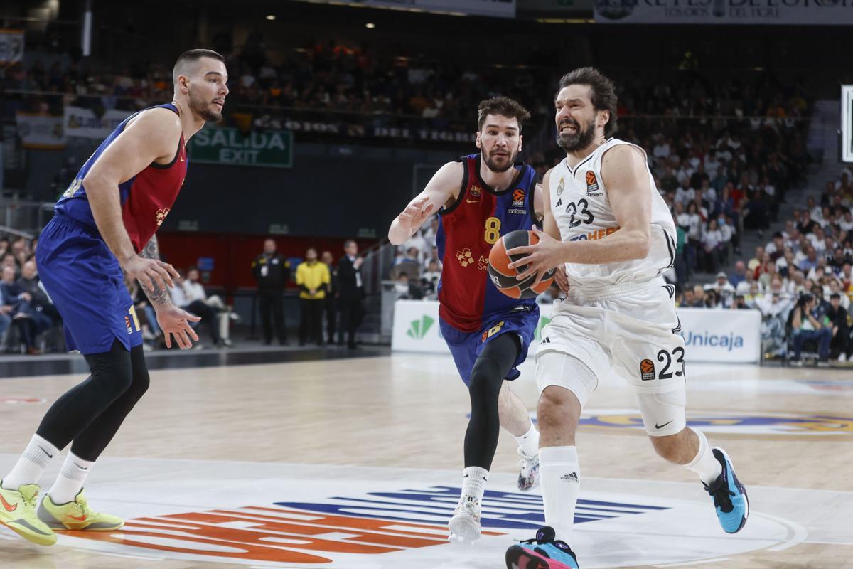El base del Real Madrid Sergio Llull entra a canasta junto a Darío Brizuela, del Barça, durante el partido de la jornada 27 de la EuroLiga.