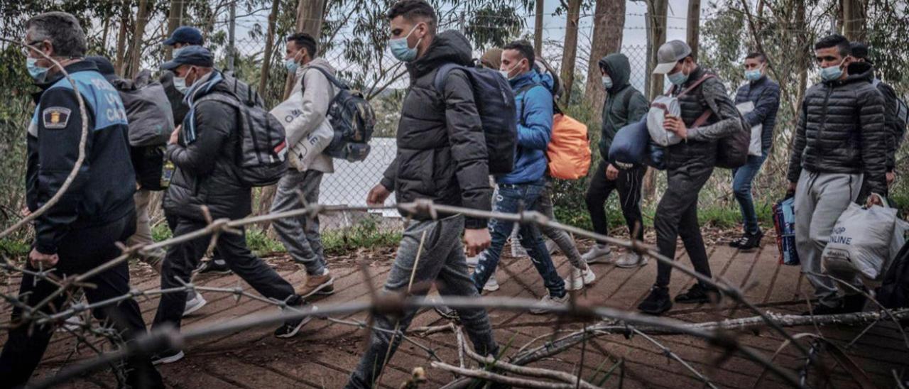 Varios de los migrantes ‘amotinados’ en Las Raíces el lunes en el camino de regreso al campamento en el que denuncian carencias. | | ARTURO RODRÍGUEZ