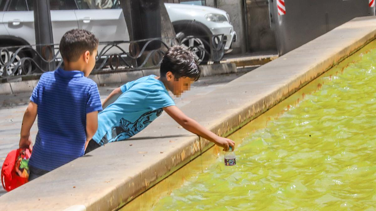 Dos niños se refrescan y juegan en una fuente de Orihuela esta semana