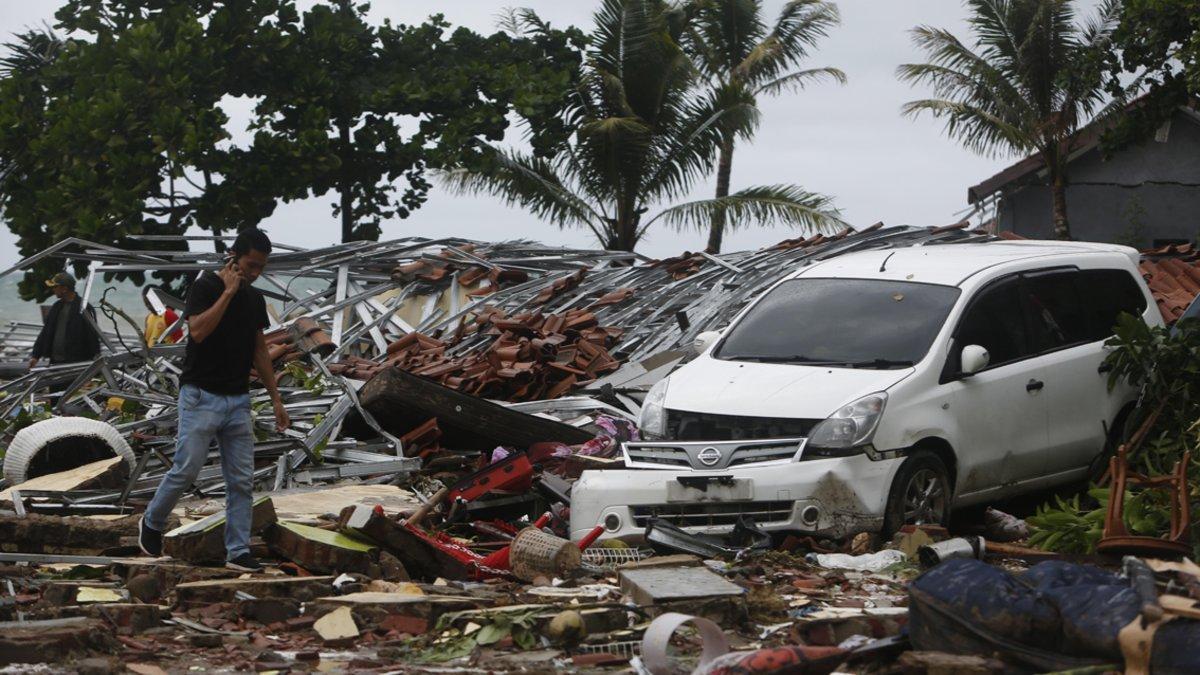 Anyer (Indonesia), 23/12/2018.- A man walks among debris, past a damaged car, after a tsunami hit the Sunda Strait in Pandeglang, Banten, Indonesia, 23 December 2018. According to the Indonesian National Board for Disaster Management (BNPB), at least 43 people dead and 584 others have been injured after a tsunami hit the coastal regions of the Sunda Strait. EFE/EPA/ADI WEDA