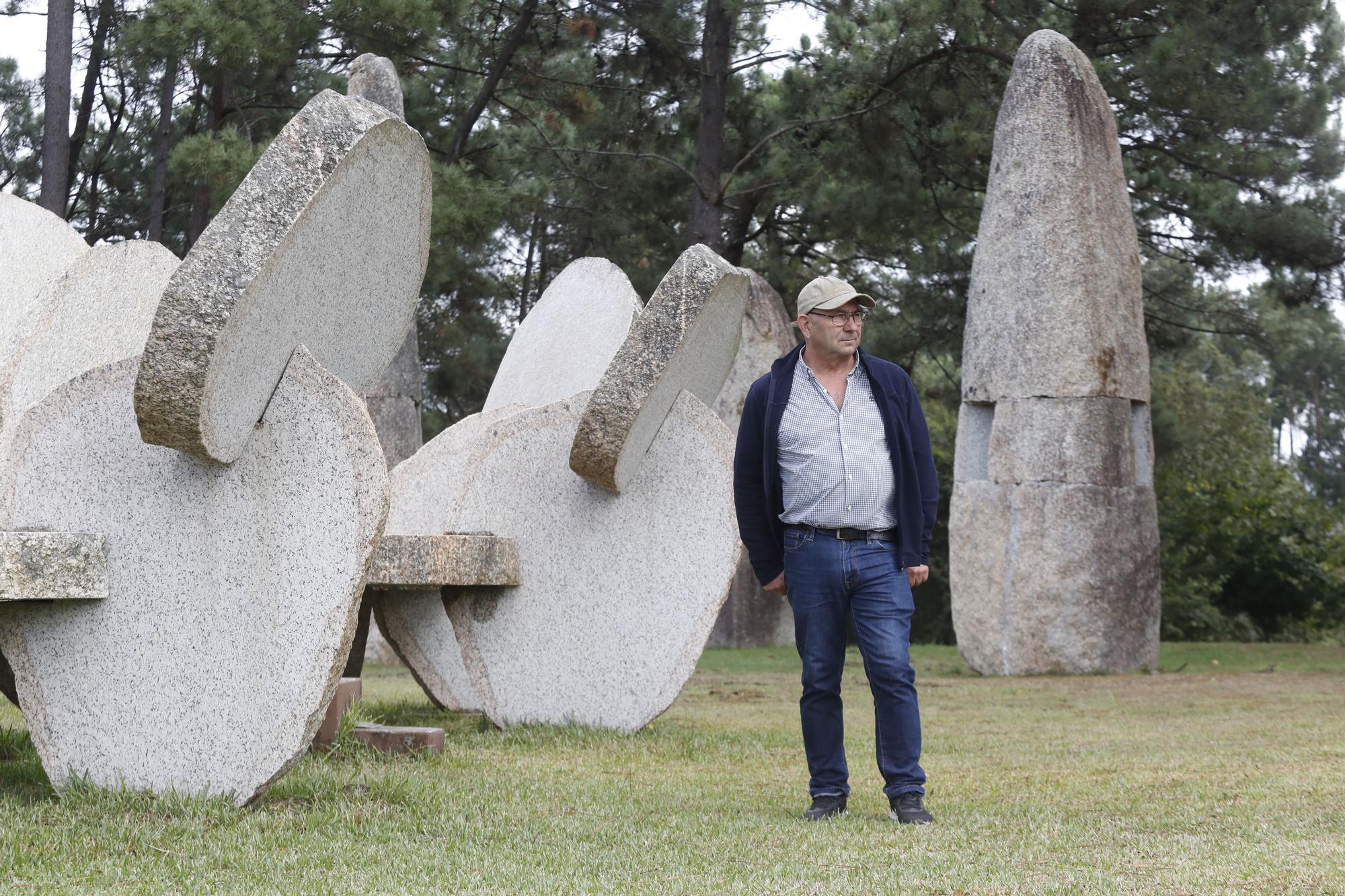 El escultor Manolo Paz junto a algunas de sus obras en su finca.