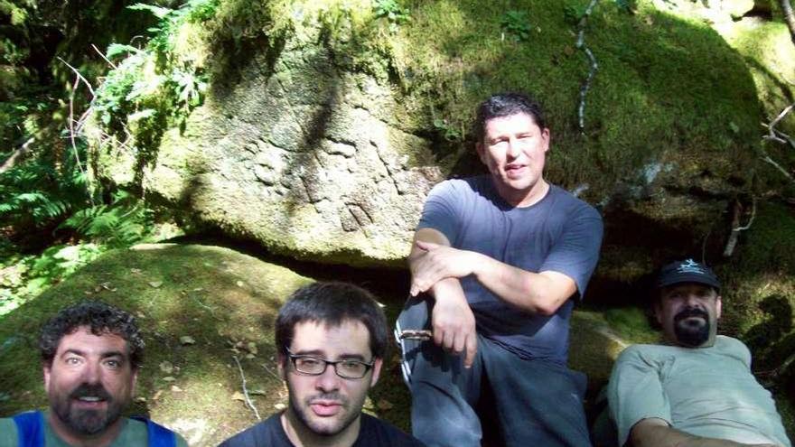 Calros Solla, Anjo Torres, Nacho Grande e Joao Bieites a carón do gravado rupestre.