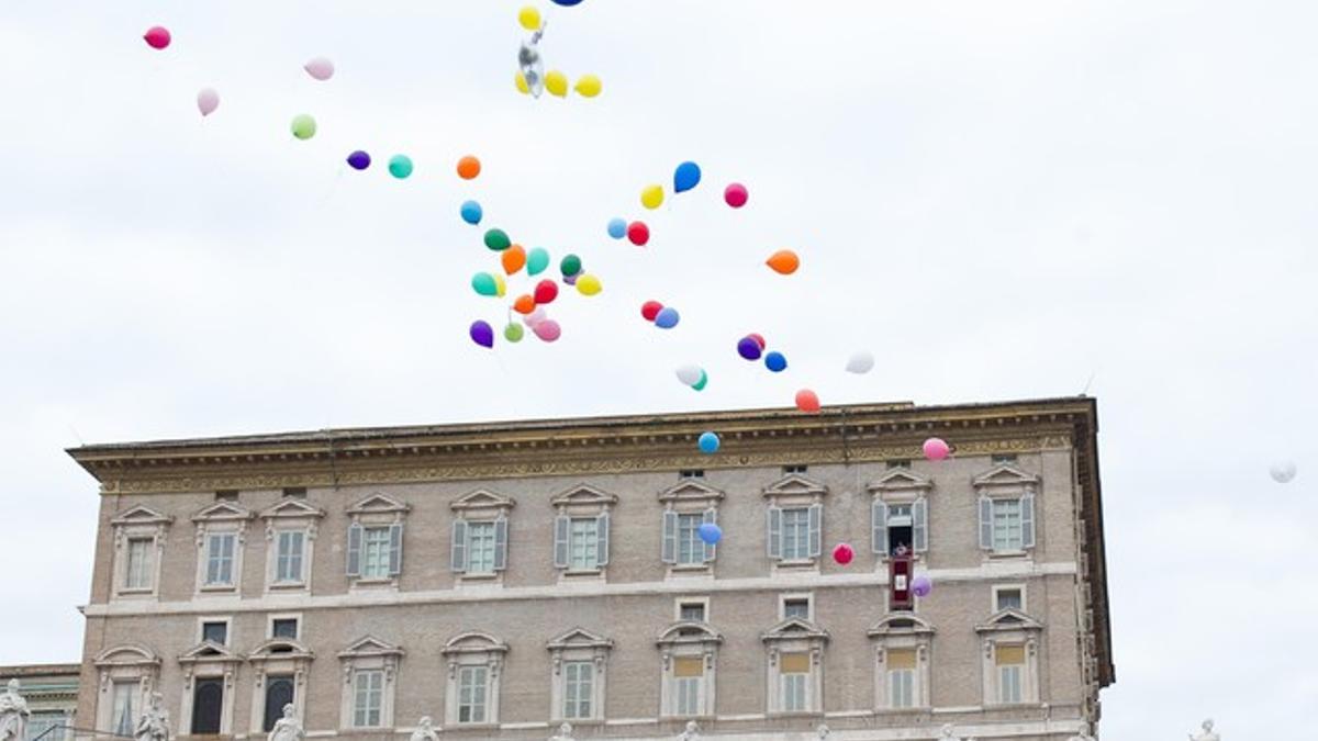 El Papa y un grupo de niños dejan ir unos globos como símbolo de paz, este domingo en el Vaticano.