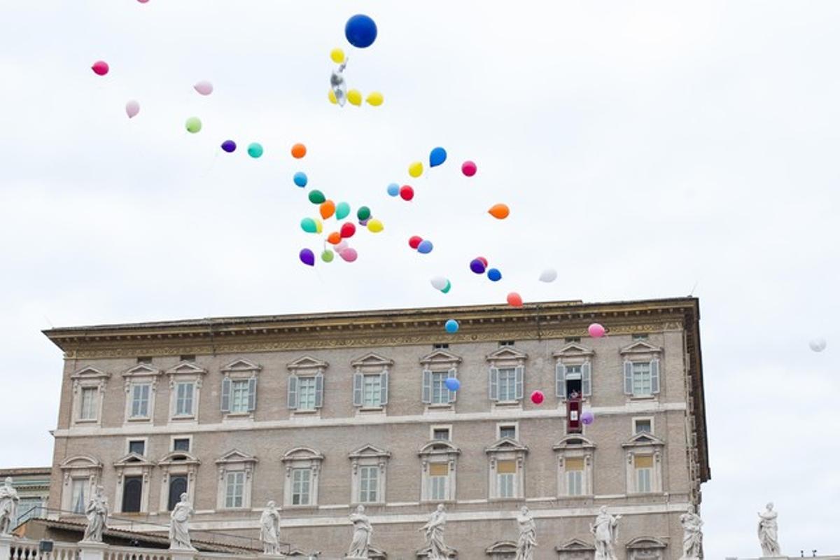 El Papa i un grup de nens deixen anar uns globus com a símbol de pau, aquest diumenge al Vaticà.