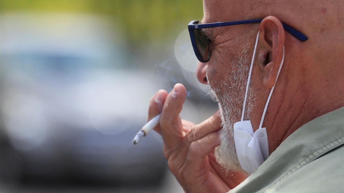 MADRID 20 08 2020 - Un hombre se fuma un cigarrillo este jueves en Madrid  La prohibicion de fumar en la calle y en las terrazas si no se cumple una distancia interpersonal de 2 metros entra en vigor este jueves en Madrid  junto con otras restricciones para evitar contagios del virus  como adelantar el cierre de bares a restaurantes a la 1 00  EFE Fernando Alvarado