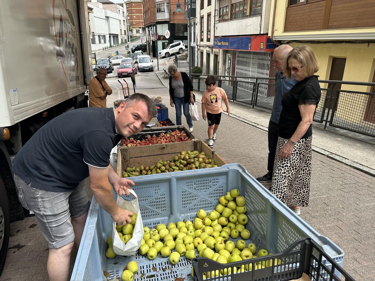 Isaac López vendiendo manzanas, en el exterior de la plaza de abastos.