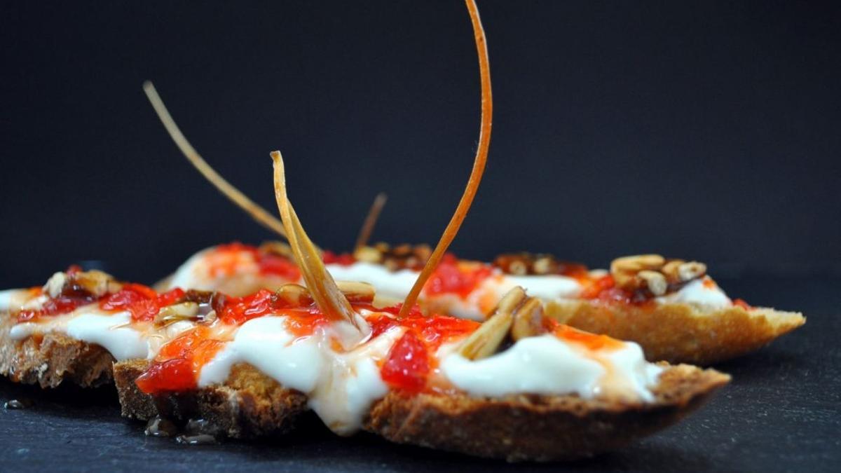 Tostadita de pan de 'farro' con yogur de La Fageda, mermelada de pimiento rojo y caramelo de piñones del restaurante Ca la Matilde, miembro del colectivo Cuina Volcànica.