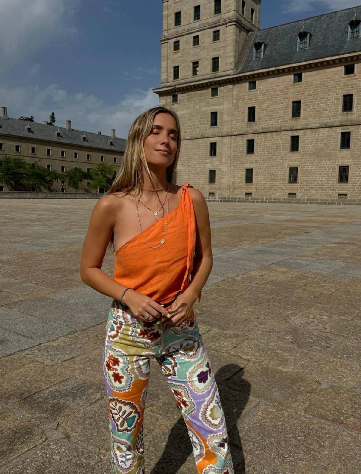 María Pombo con top naranja y pantalón estampado