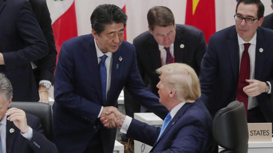 Shinzo Abe y Trump se saludan en la sesión de clausura.