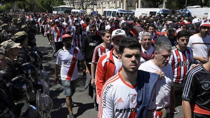 Aficionados de River abandonan el estadio Monumental, tras el aplazamiento del partido.