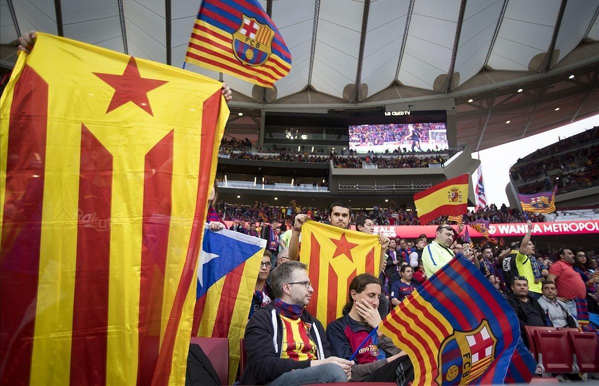 Estelades y una bandera de España en la grada.