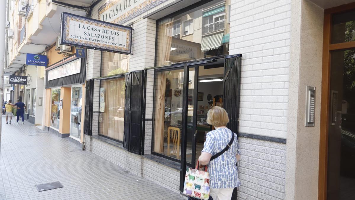 Un mujer pasa por delante de la puerta de local en el que tuvo lugar la estafa con dinero falso ayer en Xàtiva.