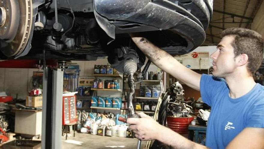 Un técnico trabaja en la reparación de un automóvil en un taller.