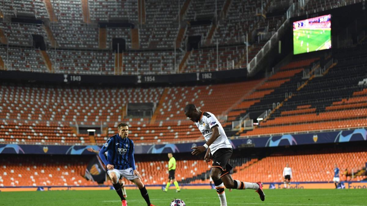 Josip Ilicic (I) ante Geoffrey Kondogbia durante el partido a puerta cerrada entre el Atalanta y el Valencia de la UEFA Champions League disputado en el Estadio Mestalla en Valencia.