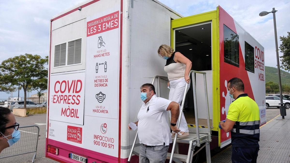 Dos personas salen este jueves del camión COVID-Express, instalado en un aparcamiento de Ibiza en el que se obtienen las muestras