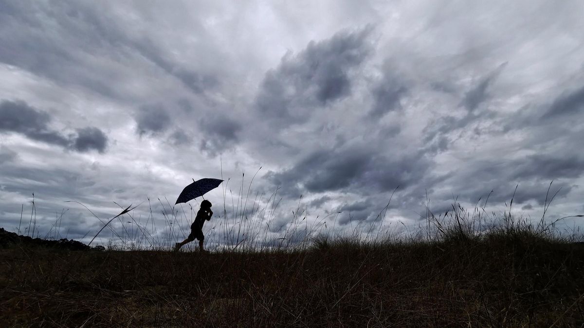 Un niño con un paraguas bajo la lluvia