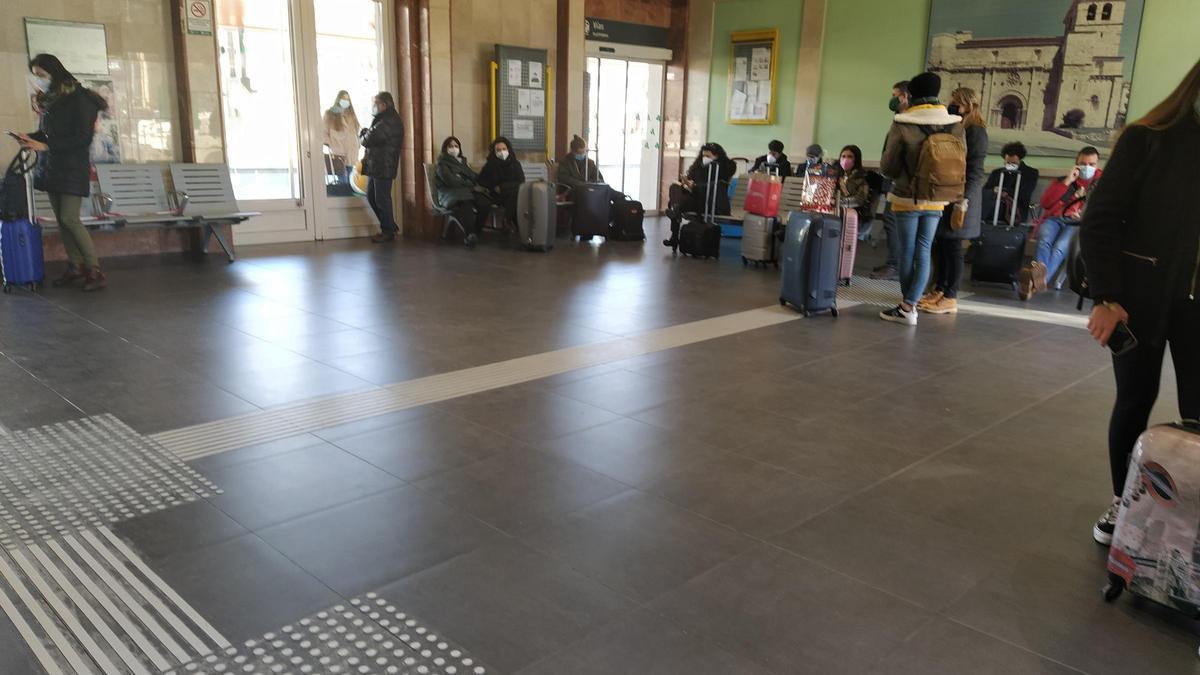 Vestíbulo de la estación de tren de Zamora, con viajeros esperando el tren a Madrid de las tres de la tarde