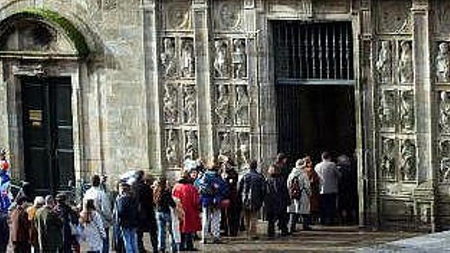 En foto de archivo, peregrinos aguardan en la cola para entrar en la Catedral de Santiago.