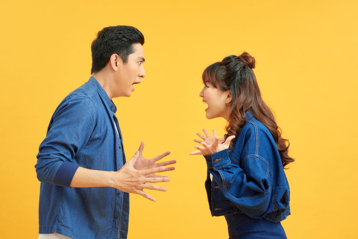 FOTO BAJADA DE 123RF EL 28 DE NOVIEMBRE DEL 2023. PAREJA ENFADADA, DISCUTIENDO, DISCUSION.. Profile side view portrait of two attractive angry aggressive nervous people having fight anger blame isolated over vivid shine bright orange background. Negative emotions concept. FOTO DE 123RF