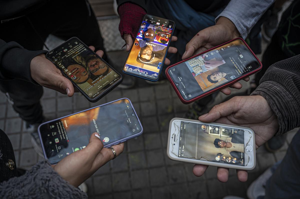 Un grupo de jóvenes, usando TikTok en la calle, en Barcelona.