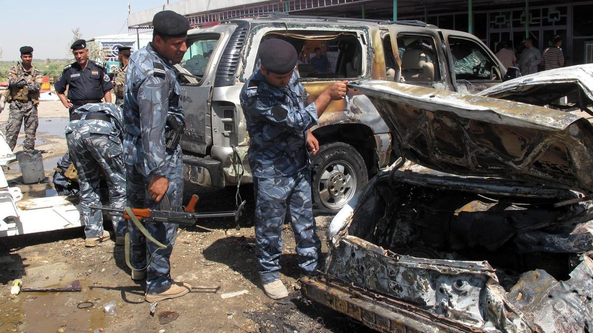 Policías iraquíes inspeccionan el sitio de un ataque con bomba.