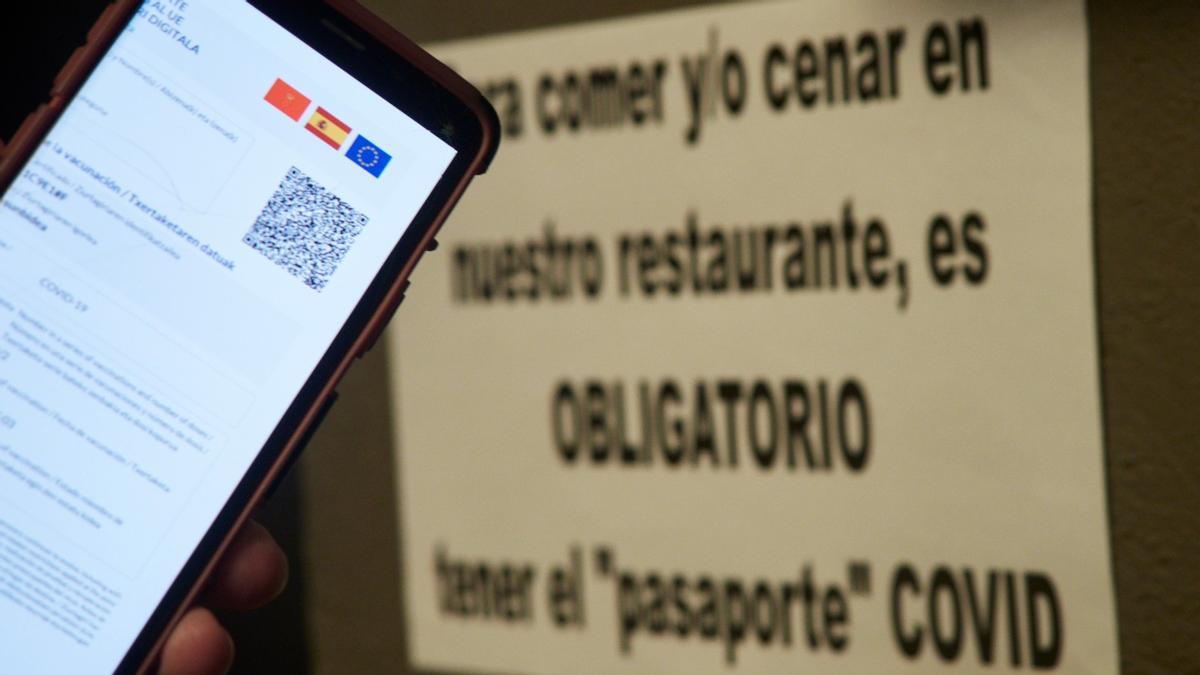 Una persona muestra su certificado de vacunación contra el covid a la entrada de un establecimiento en Pamplona, el pasado día 27