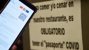 Una persona muestra su certificado de vacunación contra el covid a la entrada de un establecimiento.