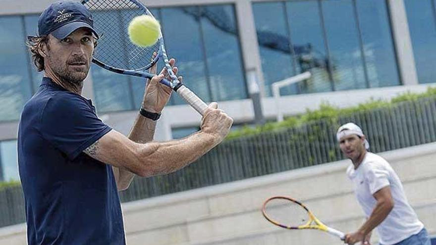 Moyá golpea la pelota, en primer plano, con Nadal al fondo.