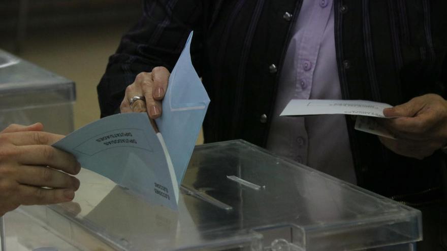 Instant en què una dona diposita el seu vot en una urna