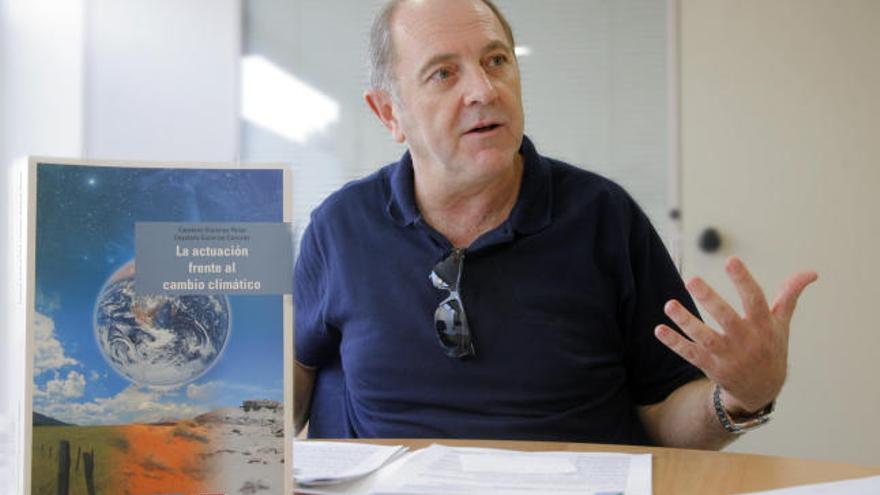 Cayetano Gutiérrez con el libro que ha publicado sobre el cambio climático