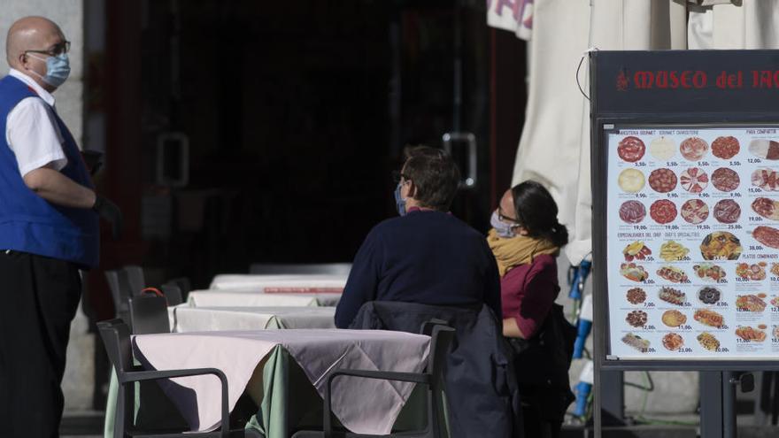 Un camarero atiende la terraza de un establecimiento ubicado en la Plaza Mayor en Madrid.