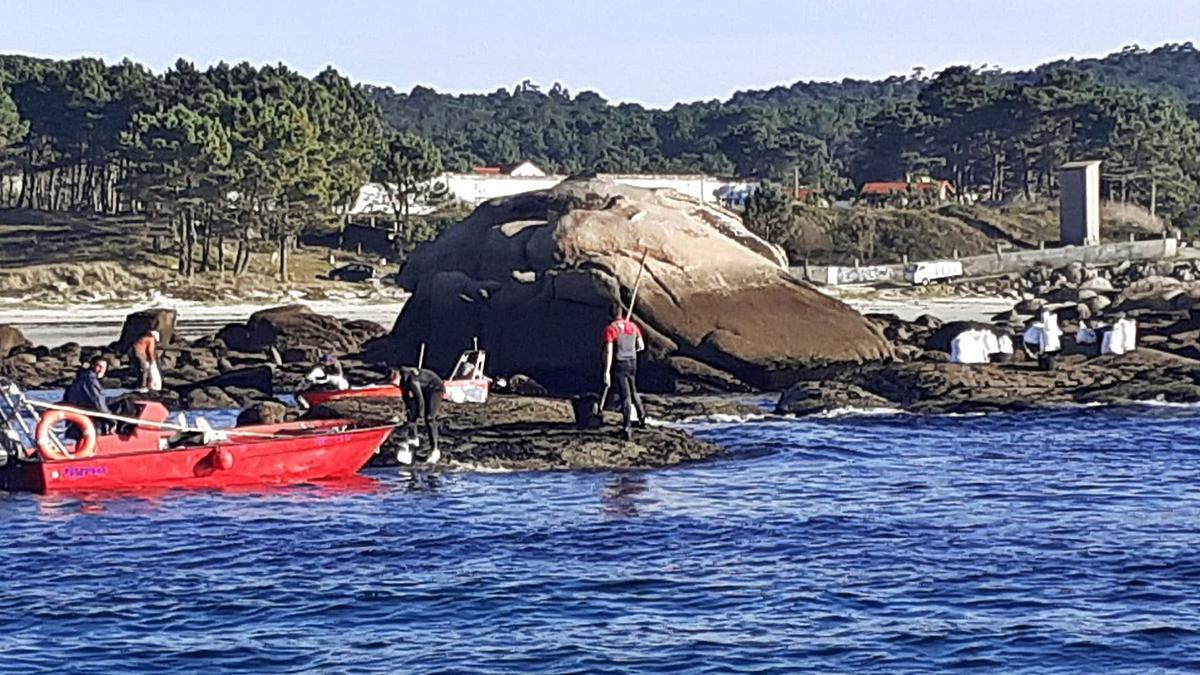 Bateeiros recogiendo ayer mejilla en Raeiros (O Grove), con una de las planeadoras que emplean para acercarse a las rocas. |  // FDV