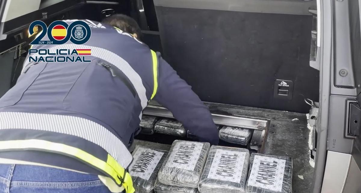 Un agente extrae ladrillos de cocaína de una caleta.