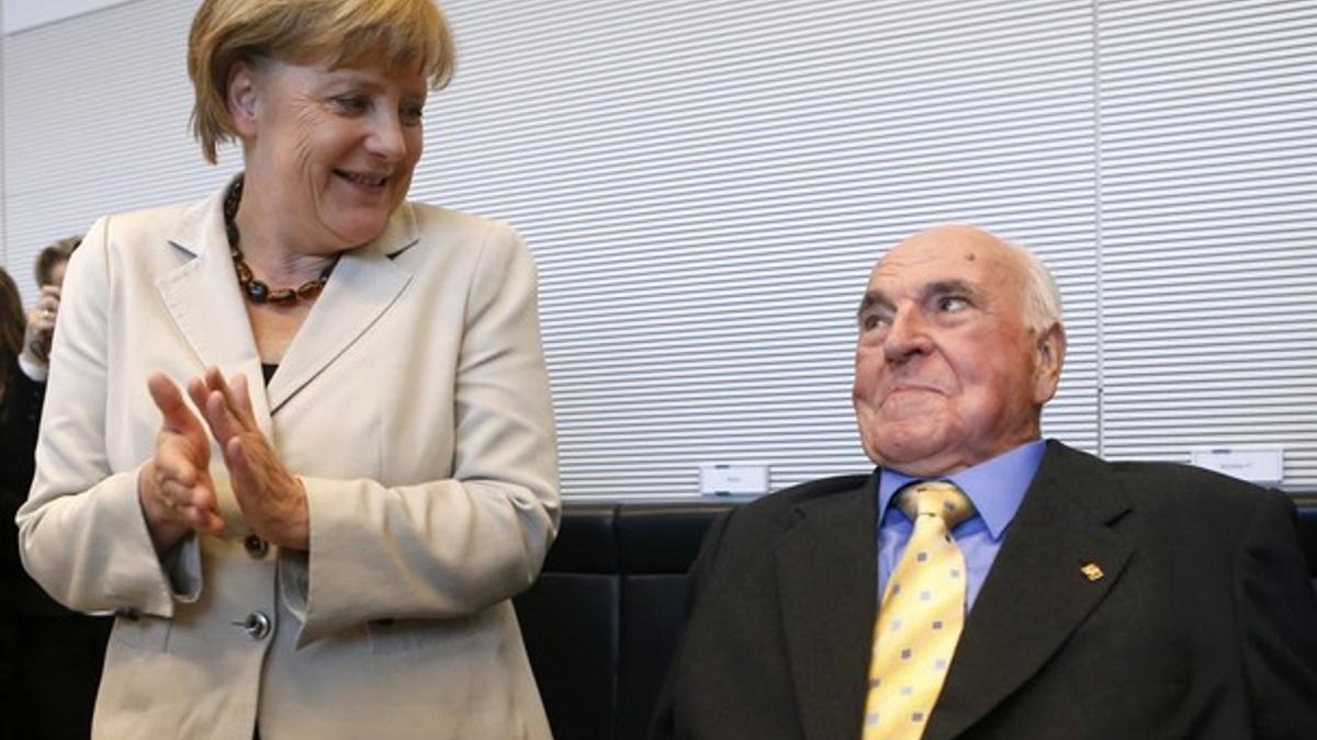 German Chancellor Merkel applauds as former German chancellor Kohl arrives for CDU and CSU party faction meeting in Berlin