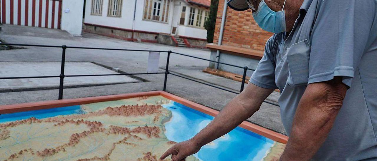 Pedro García, exalumno de las escuelas de Arnao, mirando el mapa de España restaurado.
