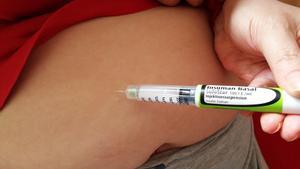 Una mujer se inyecta insulina con un bolígrafo.